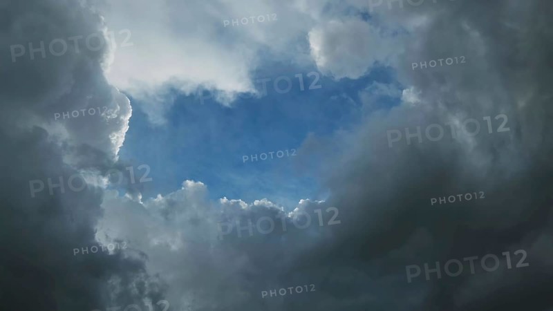 Dark storm clouds and the hole with a piece of blue sky