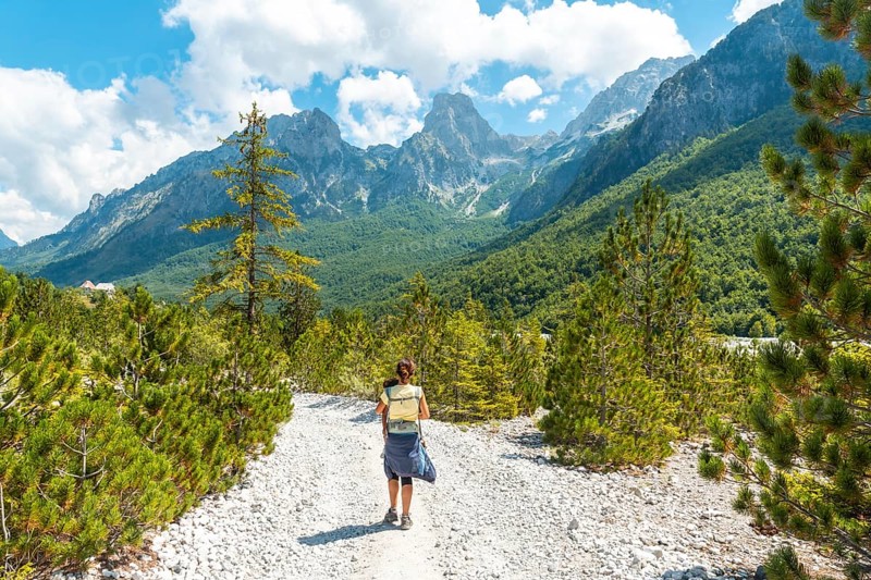 Woman hikers walking in Valbona valley next to trees, Theth national park, Albanian Alps, Albania, Europe
