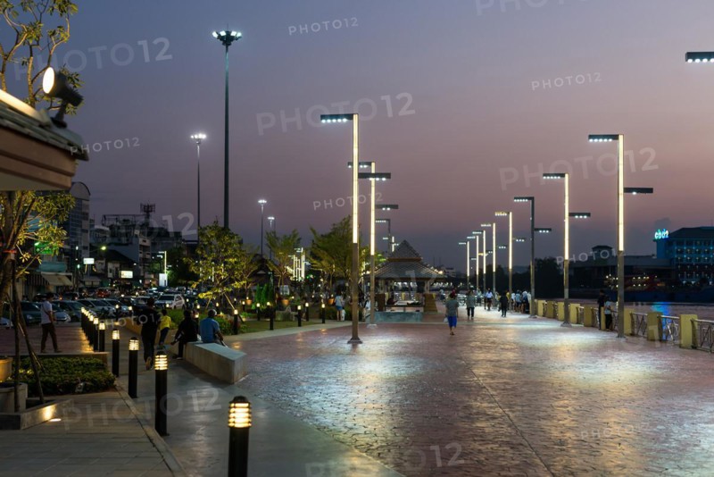 People, locals and tourists stroll and relax on the promenade of the Tapi river in Surat Thani