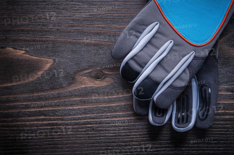 Pair of protective gardening gloves on wooden board agriculture concept