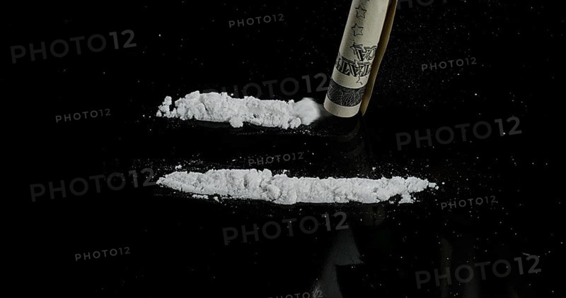 Dollar Bank notes and Powder Drug against Black Background