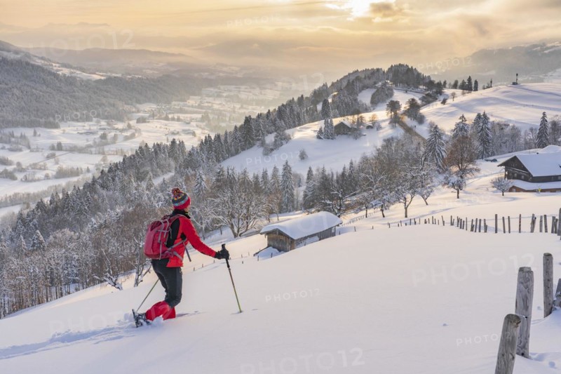 Pretty active senior woman snowshoeing in the Allgäu Alps near Oberstaufen with a view of the Bregenzerwald, Vorarlberg, Austria, Europe