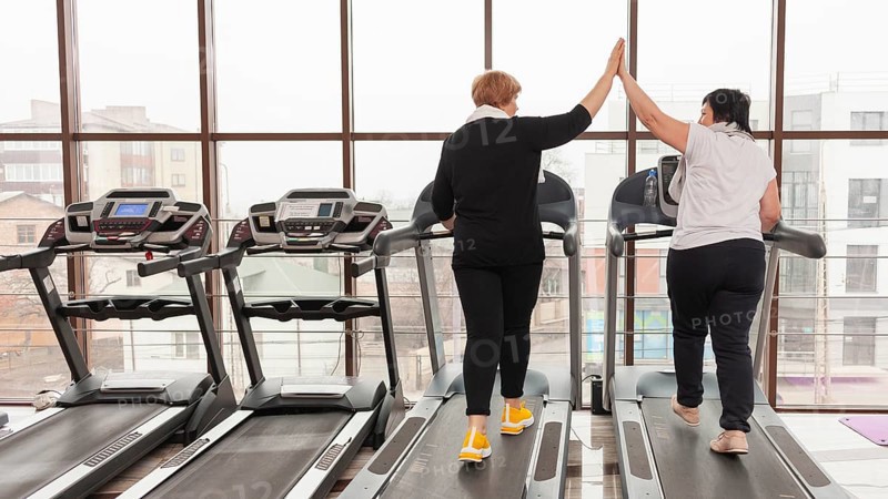Women treadmill high five
