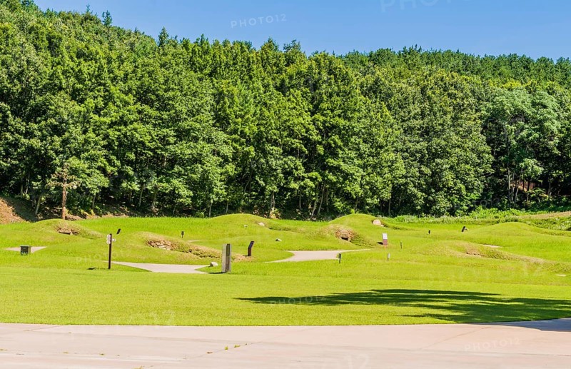 Royal tombs with entrances of stone next to treeline at Neungsa Baekje Temple, South Korea, South Korea, Asia