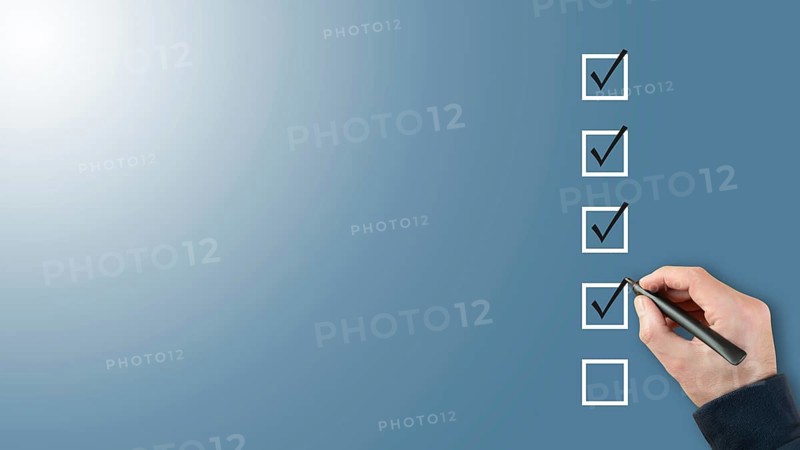 person ticking checkboxes with marker pen on checklist or to-do-list with copy space