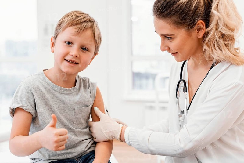 Close up pediatrician vaccinating kid