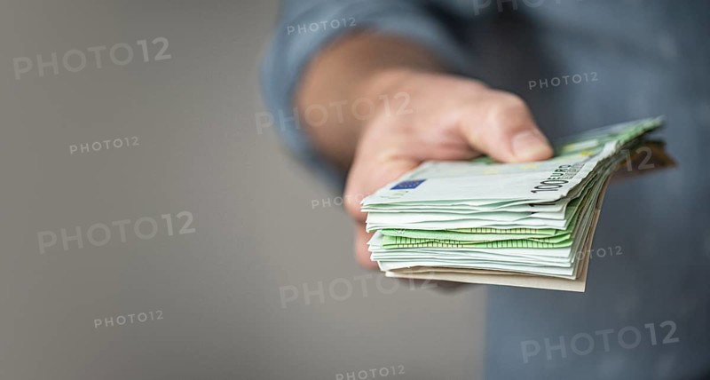 Hand giving a Stack of Euro Bills