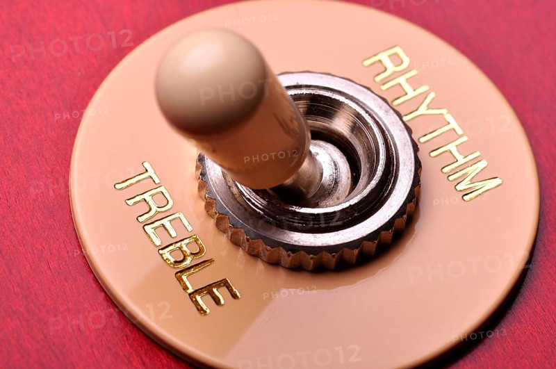 Closeup of a red electric guitar near the humbucker selector