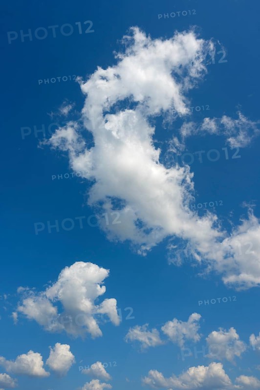White cumulus clouds ruffled by the strong wind in the blue sky