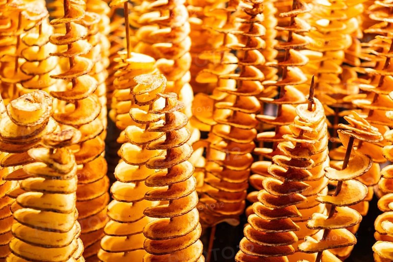 Spiralised potatoes on a wooden skewer at the Mercado de la Boqueria in Barcelona, Spain, Europe