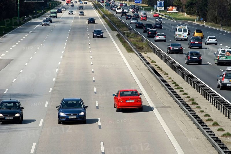 Ghost driver in red BMW driving wrong direction on three lane freeway, Autobahn A8 east of Munich, Bavaria, Germany, digital compositing, Europe