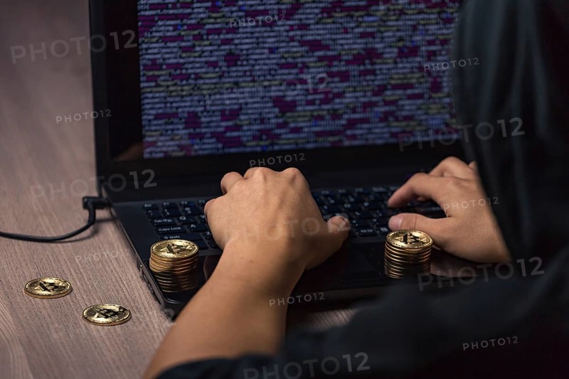 Dangerous hooded hacker on laptop breaks computer security sistem and steal bitcoin cryptocurrency
