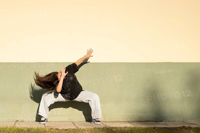 Tennage girl dancing on the street. Copy space