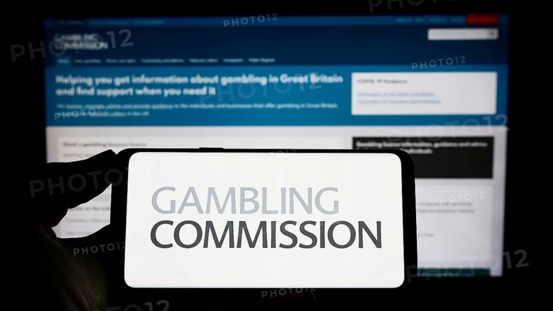 Stuttgart, Germany, 04-01-2023: Person holding mobile phone with logo of British public body Gambling Commission on screen in front of web page. Focus on phone display, Europe