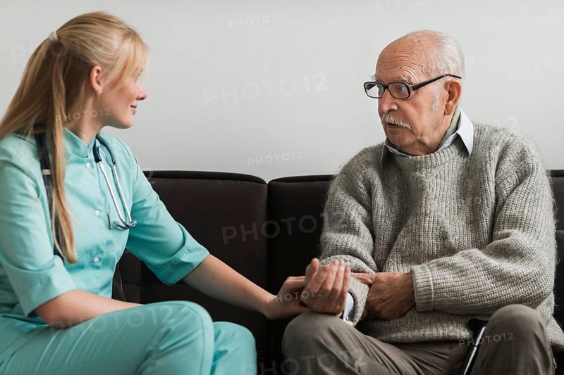 Nurse consoling old man nursing home
