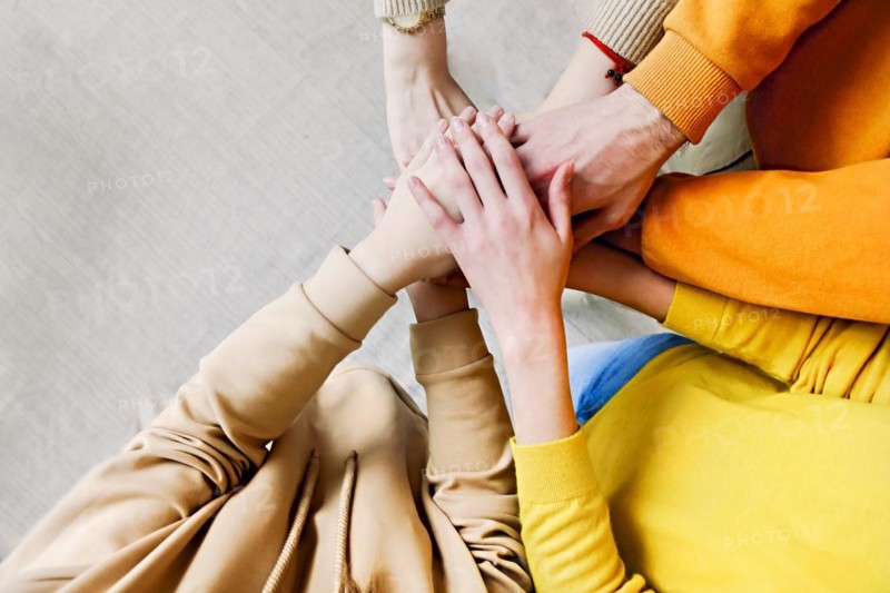 Pile of hands of friends. Teenagers putting their hands together. Close up