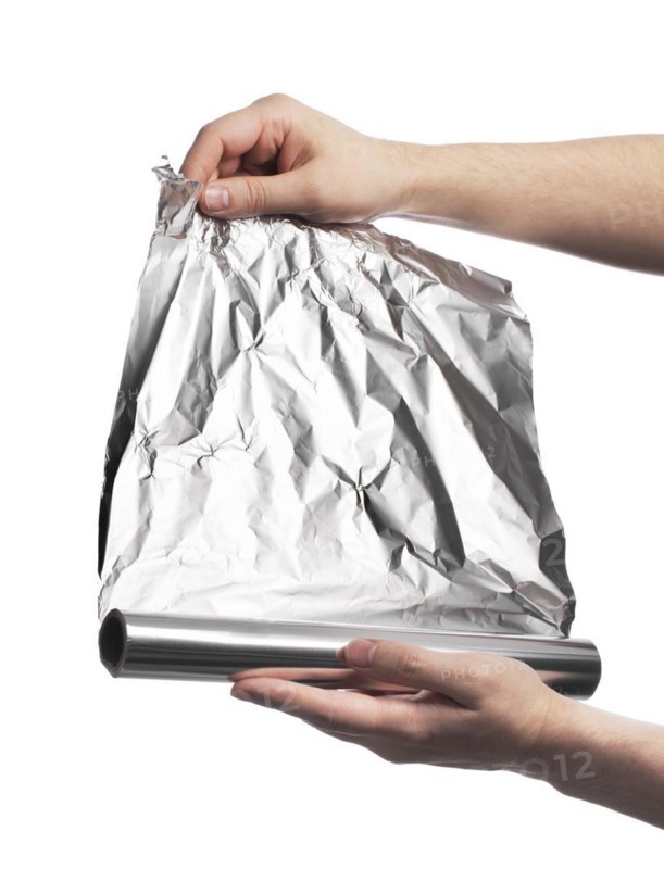 Man holding a roll of household aluminum foil