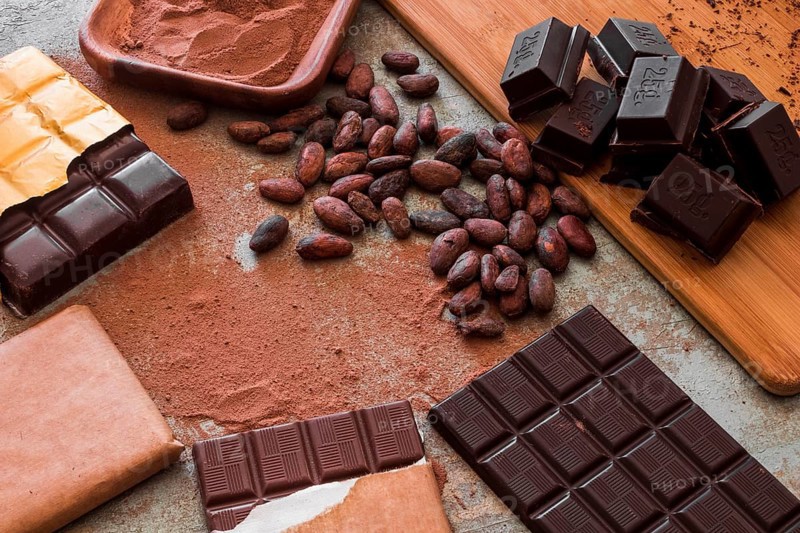 Overhead view chocolate bars with cocoa powder raw beans