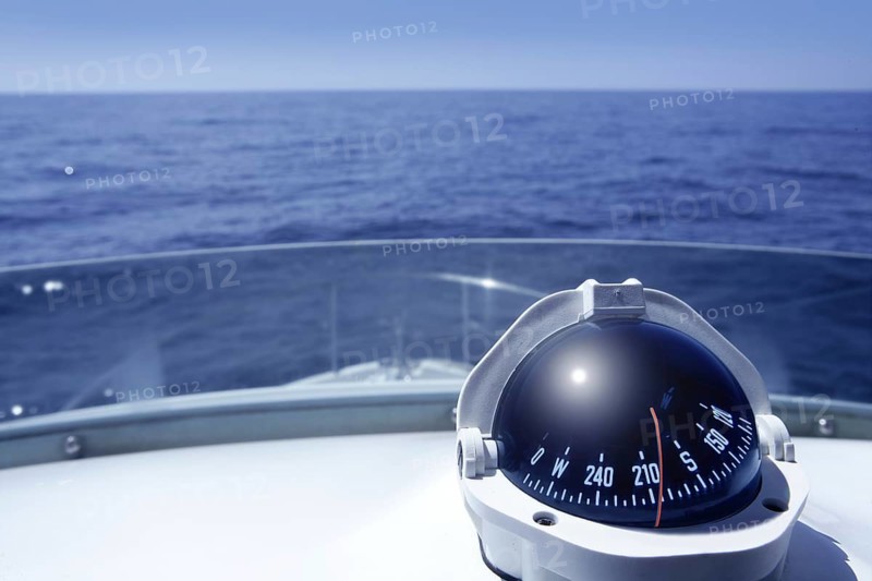 Compass on a yacht boat tower on a blue summer sea ocean day