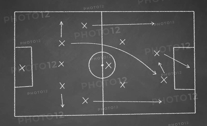Soccer game strategy drawn with white chalk on a blackboard