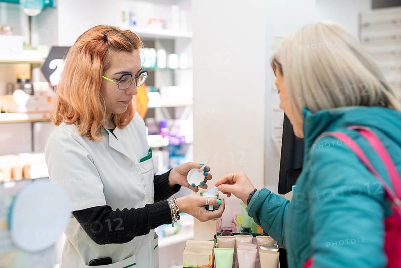 A pharmacist assists a client, showing her essential products. The image reflects the importance of expert advice for an informed choice of health products