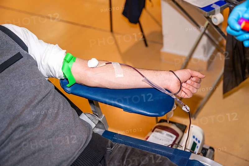 Top view close-up of a man resting while donating blood in a center