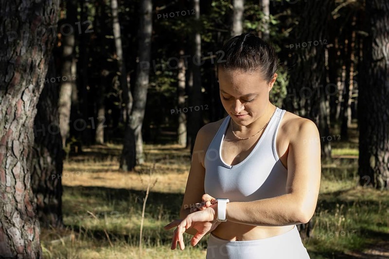 Young athletic woman looking at the stopwatch timer for her training session