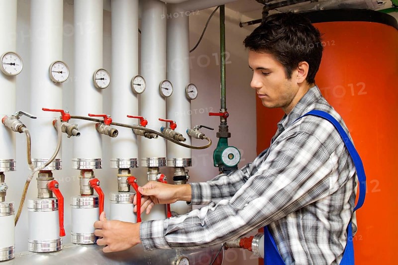Young heating technician maintains a heating system, Austria, Europe