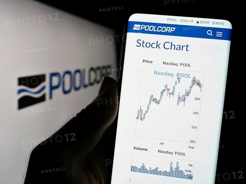 Stuttgart, Germany, 08-06-2023: Person holding mobile phone with website of US company Pool Corporation (POOLCORP) on screen in front of logo. Focus on center of phone display, Europe