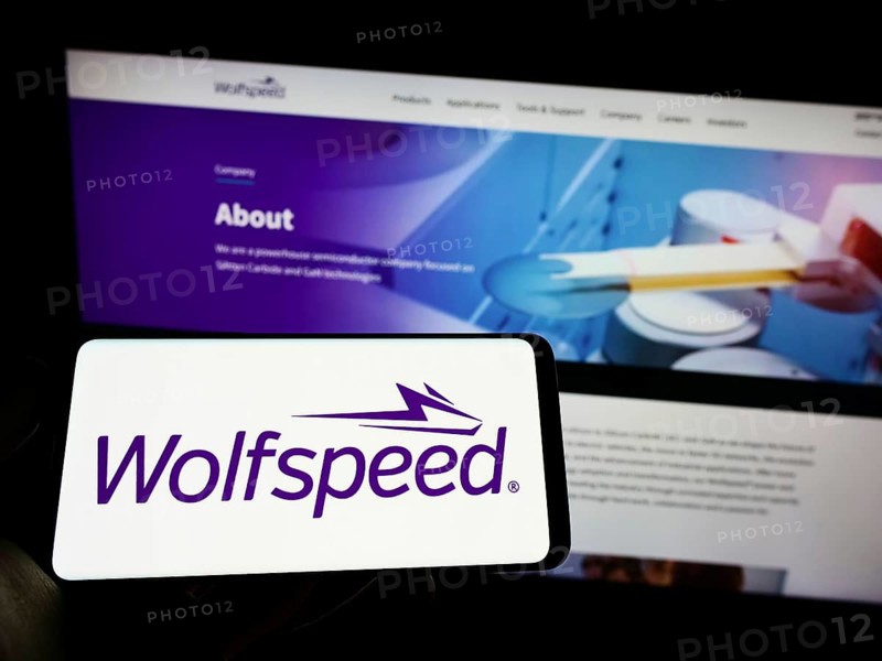 Stuttgart, Germany, 09-20-2022: Person holding cellphone with logo of US semiconductor company Wolfspeed Inc. on screen in front of business webpage. Focus on phone display, Europe