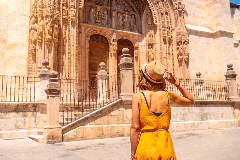 Young woman at the entrance door of the church of Santa María la Real in Aranda de Duero in the province of Burgos. Spain