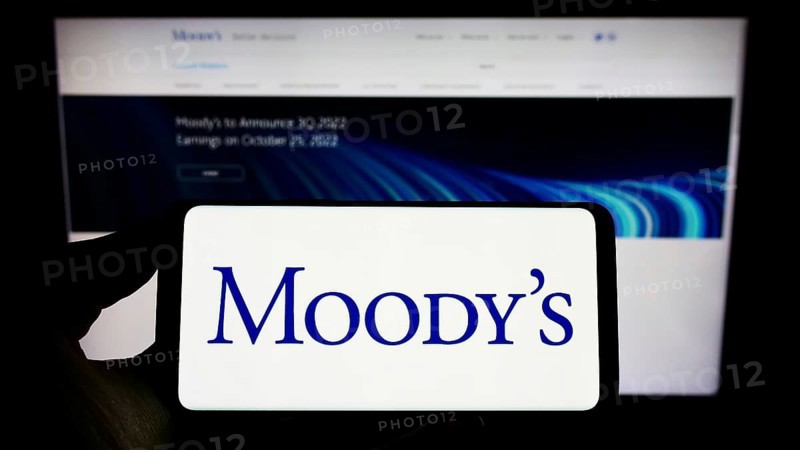 Stuttgart, Germany, 10-09-2022: Person holding cellphone with logo of rating company Moody's Investors Service Inc. on screen in front of webpage. Focus on phone display, Europe