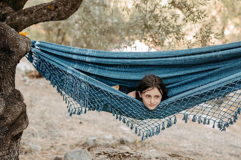 Girl lying in a hammock stretched between two trees