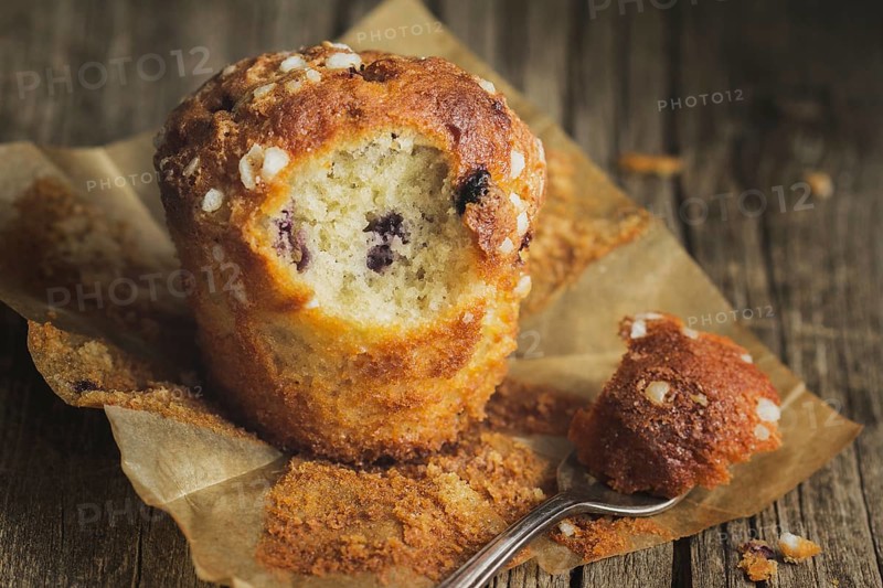 Blueberry muffin on baking paper with fork