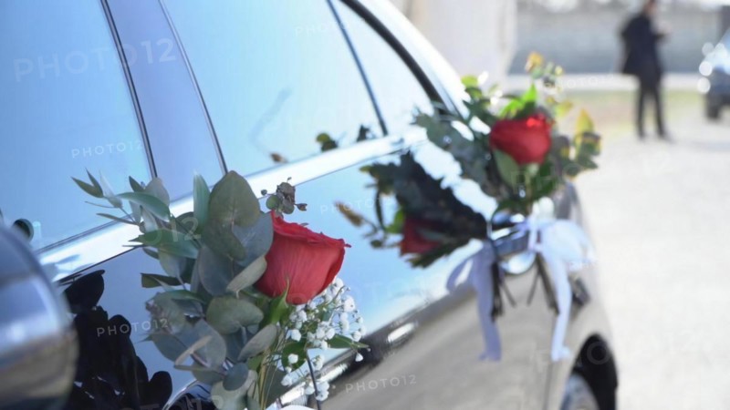 Wedding car decorated with flowers and ribbons, closeup
