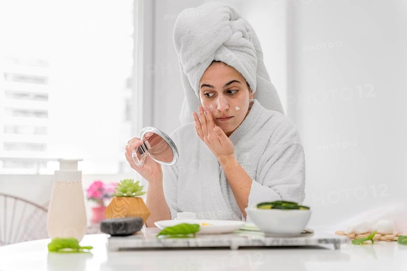 Front view woman applying face cream