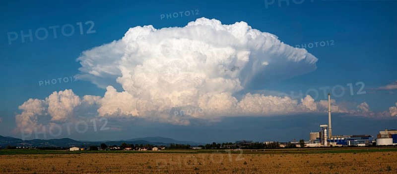 A storm cloud (Cumulonimbus) formed into an anvil over the Bavarian forest, Südzucker factory, Plattling, Lower Bavaria, Germany, Europe