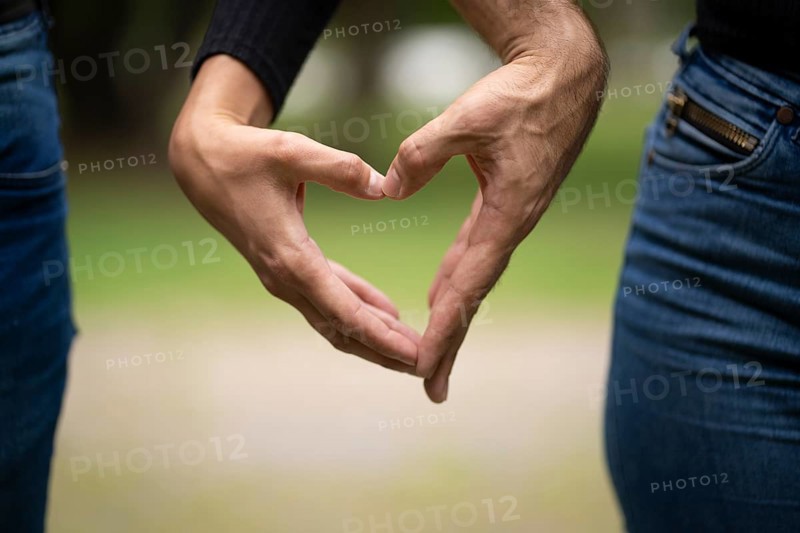 Couple holding hands making a heart