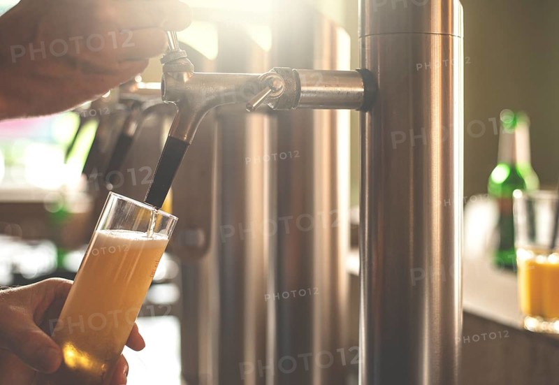 A landlord taps beer in a bar