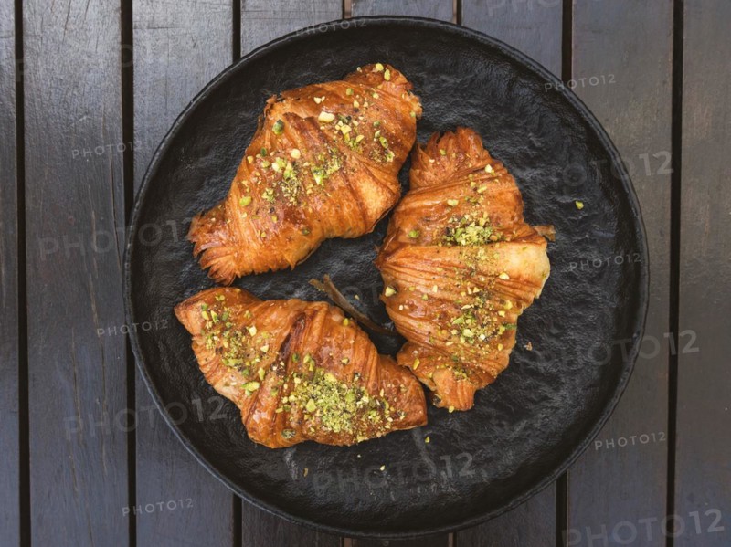 High angle view of three croissants with pistachios on top of them