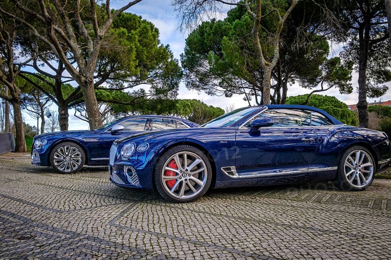Lisbon, Portugal, Jan 20, 2024: Luxury Bentley Flying Spur Mulliner sedan and Bentley Continental GTC Azure convertible coupe parked on a cobblestone road, dark blue body and silver rims, unique grille and Mulliner and Azure make badge, Europe
