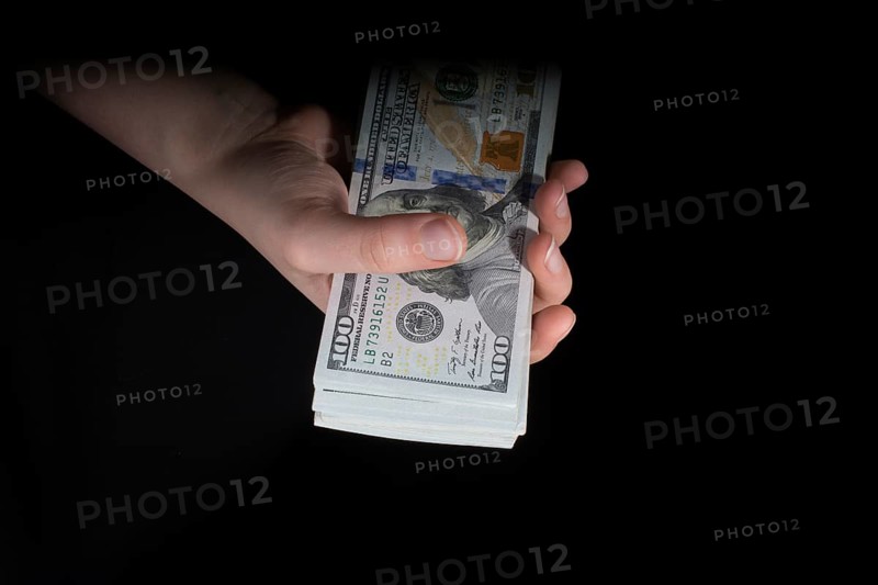 Hand holding American dollar banknotes isolated on white background
