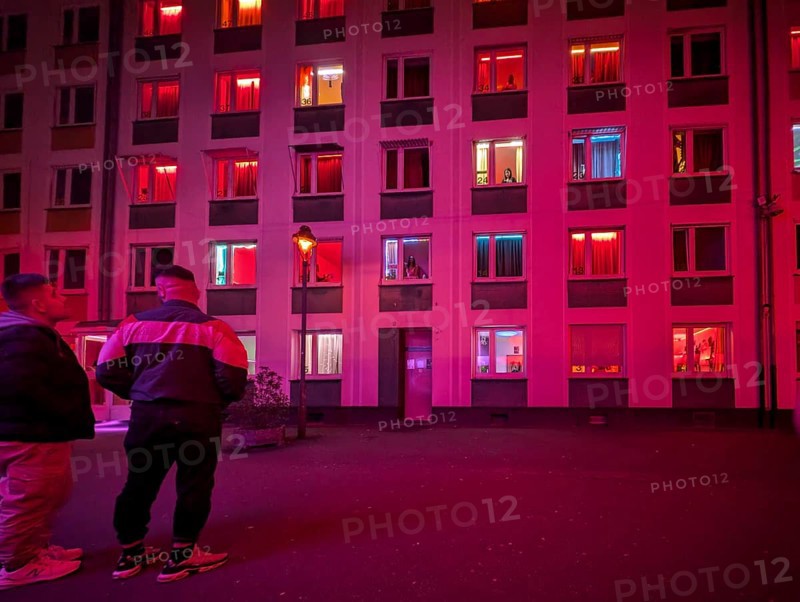 Laufhaus, clients in front of the facade of a red-lit brothel with prostitutes in the windows, Düsseldorf, North Rhine-Westphalia, Germany, Europe