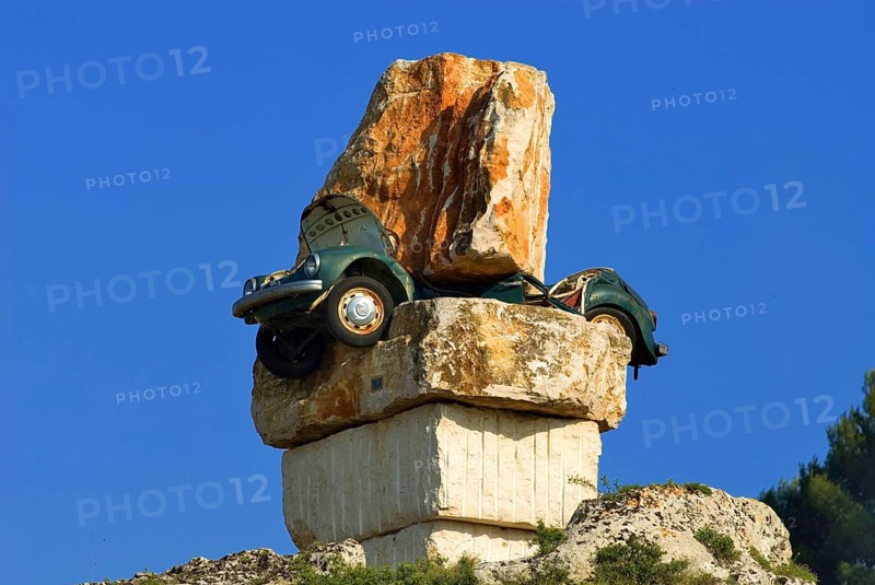 Art in south Italy, a green VW beetle totally crushed between huge boulders, Italy, Europe, Symbol, Europe