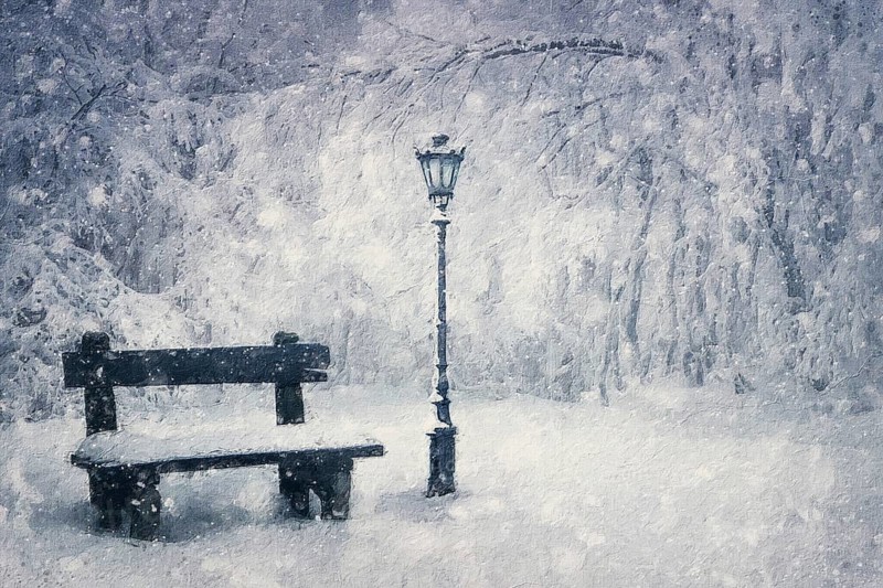 Winter season painting of a wooden bench and street lamp covered with snow under a snowfall in the park. Wonderful holiday scene, Christmas magic atmosphere. Tranquil and peaceful view