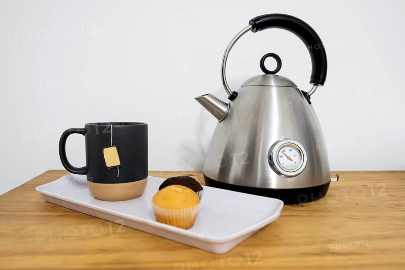 Tray with muffins and tea, electric kettle. Concept of pause, refreshment, relaxation