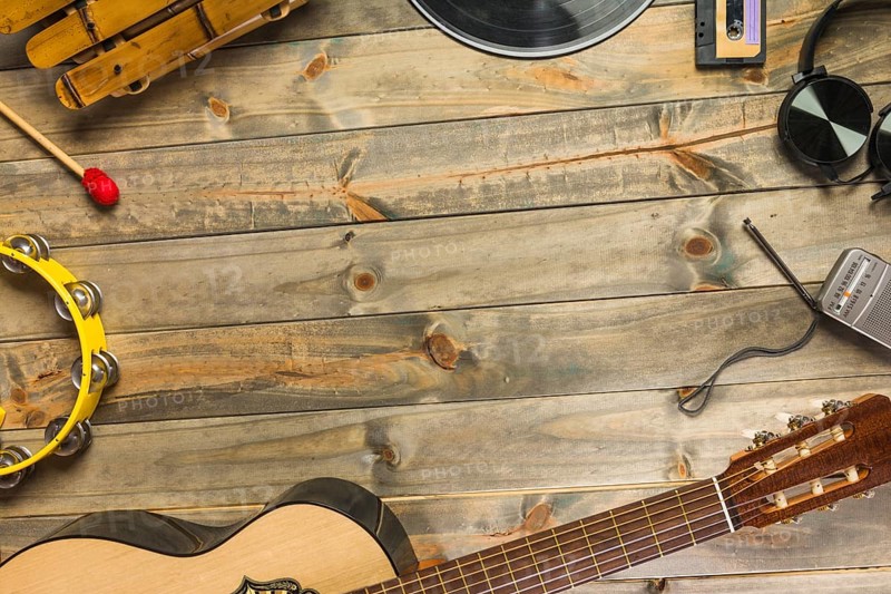 Close up guitar headphone tambourine xylophone headphone radio wooden table with space text. Beautiful photo