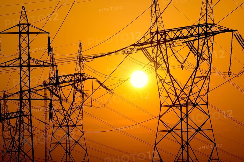 Transmission towers on sunset sky
