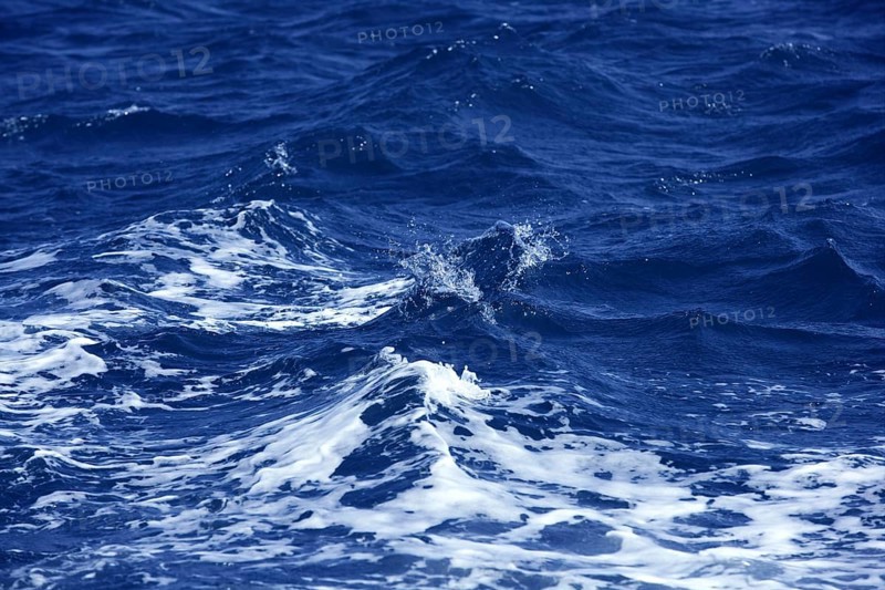 Blue wawy water with white foam in storme sea ocean surface