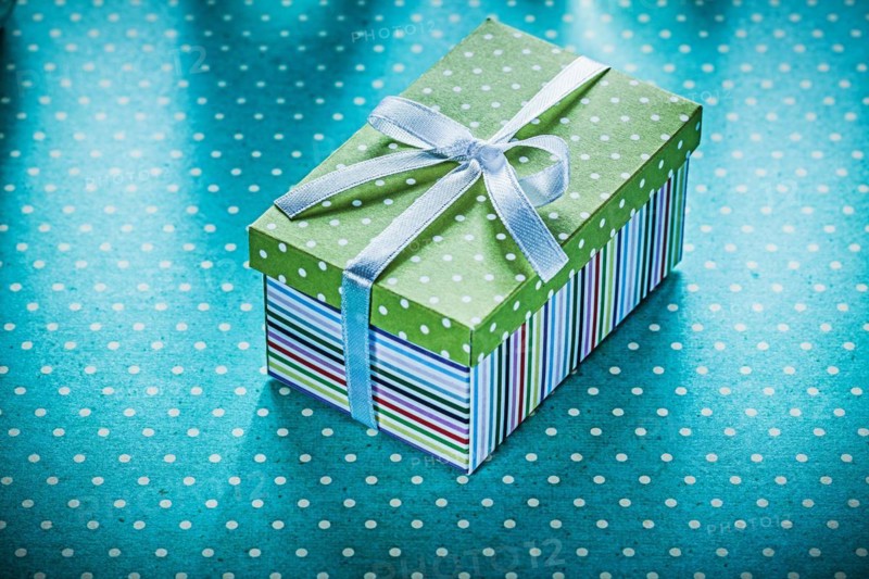 Wrapped gift on blue dotted tablecloth Holiday concept